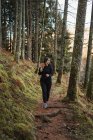 Donna che cammina nella foresta autunnale — Foto stock