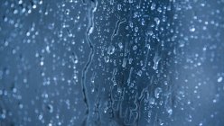 Gotas de agua sobre fondo azul - foto de stock