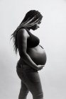 Heureuse femme enceinte afro-américaine tenant la main sur le ventre — Photo de stock