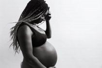 Felice donna afro-americana incinta che si tiene per mano sulla pancia — Foto stock