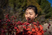 Angenehm charmante asiatische Frau berühren Zweig mit roten wilden Beeren — Stockfoto