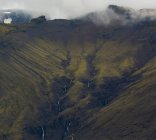 Scenic view of majestic colorful mountain ridges with cascades in cloudy day in Iceland — Stock Photo