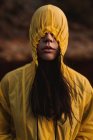 Mujer en impermeable amarillo paseando en la naturaleza - foto de stock