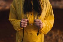 Donna in impermeabile giallo passeggiare nella natura — Foto stock