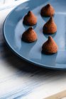 Placa com saborosas trufas de chocolate na mesa — Fotografia de Stock