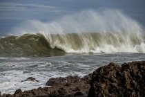 Грубые волны разбиваются на пирсе во время прилива — стоковое фото