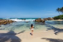 Dame im Badeanzug ruht sich an exotischer, einsamer Küste aus — Stockfoto
