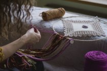 Cropped image of woman creating handmade dreamcatcher with long threads spending time in house — Stock Photo