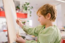 Малюк малює на полотні вдома — стокове фото