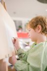 Criança desenhando sobre tela em casa — Fotografia de Stock