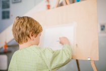 Ребенок рисует на холсте дома — стоковое фото