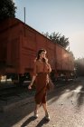 Woman wearing terracotta clothes in vintage style standing near terracotta car train and holding open book in hands — Stock Photo