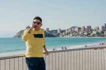 Conteúdo viajante masculino chamando no smartphone à beira-mar — Fotografia de Stock