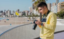Творческий молодой фотограф снимает на набережной — стоковое фото