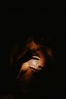 Alto ângulo de mulher nua cobrindo peito com mão e segurando bola luminosa no escuro — Fotografia de Stock