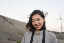 Joyeuse femme asiatique en vacances souriant à la caméra tout en explorant la campagne de Taiwan — Photo de stock