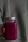 Person holding glass jug of delicious berry smoothie — Stock Photo