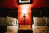 Мильна і сучасна спальня з подушками, лампою і червоним шпалерним паперу в готелі на пляжі Венеції. — стокове фото