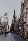 Vecchia torre scura situata tra vecchie case contro il cielo grigio coperto sulla strada cittadina di Edimburgo, Scozia, Regno Unito — Foto stock