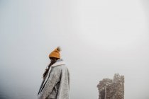 Vista lateral da senhora em roupas quentes andando no parque nebuloso no dia nublado — Fotografia de Stock