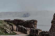 Blick von zerstörten Häuserwänden auf neblige Berge und Hügel mit Nebel am bewölkten Tag — Stockfoto