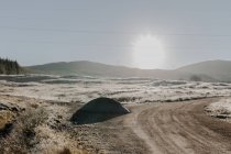 Route enneigée avec virage à la campagne en passant par les montagnes au lever du soleil — Photo de stock