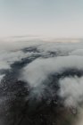 Luftaufnahme einer dicht besiedelten Stadt mit Straßen und Häusern, die hinter weißen Wolken verborgen sind — Stockfoto