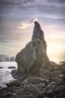 Felsen im Meer gegen grüne Klippe — Stockfoto