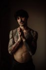 Bonito homem sem camisa com bigode, piercing e tatuagens posando em estúdio — Fotografia de Stock
