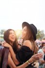 Обаятельные длинноволосые стильные друзья веселятся в светлый день на фестивале — стоковое фото