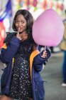 Cheerful African American woman with cotton candy — Stock Photo