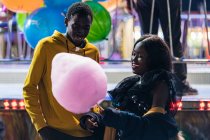 Happy black couple eating candy floss — Stock Photo