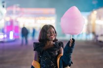 Cheerful African American woman with cotton candy — Stock Photo