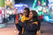 Schwarzes Paar macht Selfie auf Jahrmarkt — Stockfoto