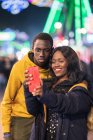 Black couple taking selfie on fairground — Stock Photo
