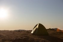 Одинокая палатка в пустой равнине в яркий день — стоковое фото