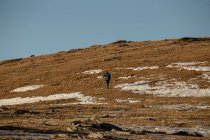 Voyageur avec sac à dos marchant le long de la vallée sèche en montagne — Photo de stock