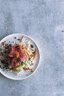 Dall'alto salmone affettato appetitoso saporito su riso bianco con verdure in piatto su tavolo con spazio di copia — Foto stock