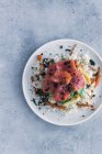 De arriba sabroso apetitoso el salmón en rodajas sobre el arroz blanco con hortalizas en el plato a la mesa con el espacio de copia - foto de stock