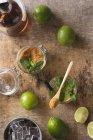 Накладні свіжі лапки і листя м'яти поміщають на серветку і стіл біля рому і коричневий цукор для приготування мохіто — стокове фото