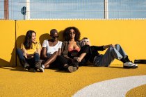 Cheerful young multiracial female students enjoying pastime on stadium — Stock Photo