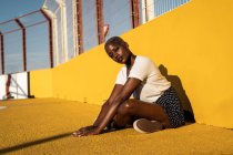 Confident young woman sitting on ground on stadium — Stock Photo