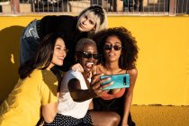 Jovens alegres diversas amigas tirando selfie no smartphone na rua — Fotografia de Stock