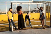 Сосредоточенные молодые многорасовые подруги проводят свободное время вместе на стадионе — стоковое фото