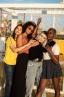 Fokussierte junge multirassische Freundinnen verbringen ihre Freizeit gemeinsam im Stadion — Stockfoto