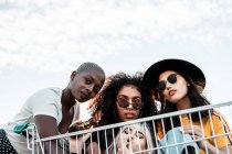 Багаторасова група молодих жінок, що стоять навколо кошика на дорозі — стокове фото