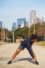 Спортсмен іспанського походження в активному одязі стоїть і згинається в центрі Далласа, Уса. — стокове фото