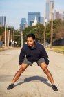 Atleta masculino hispânico em desgaste ativo de pé e flexão no centro de Dallas, EUA — Fotografia de Stock