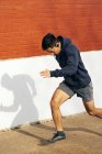 Seitenansicht von fit hispanischen sportlichen Mann Musik hören beim Joggen entlang der Straße in Dallas — Stockfoto