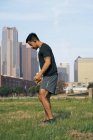Hispanic sporty man in active wear warming in green park of Dallas, Texas, USA — Stock Photo